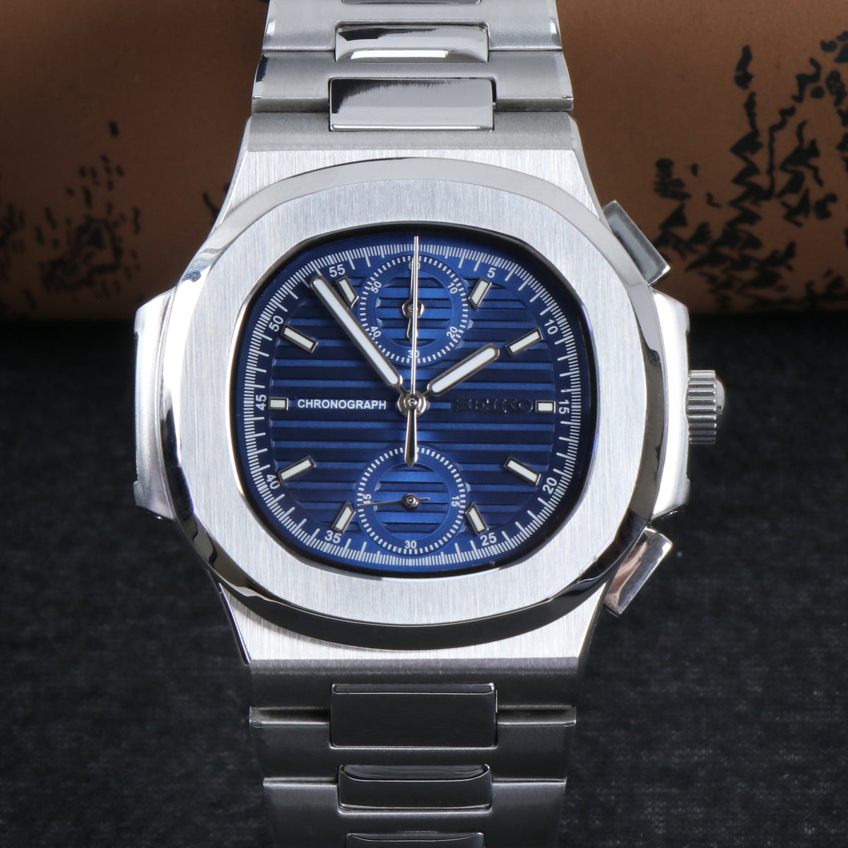 Silver watch with a blue face on a dark textured background