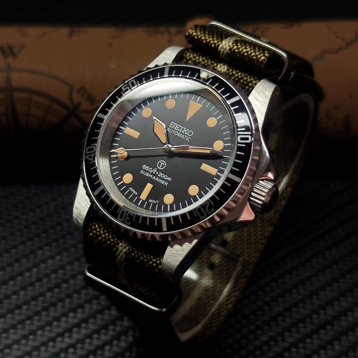 Seiko watch with black dial and brown strap on a textured surface