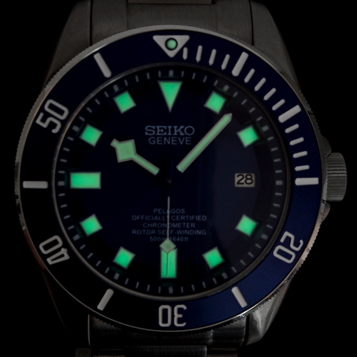 Seiko watch with glowing green face on a black background